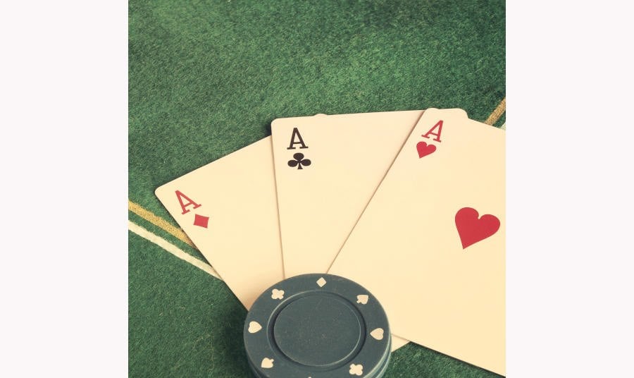 Detail of three aces and blue poker chips