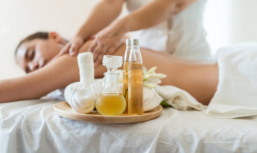 Bottle of essential oil on a wooden tray. 