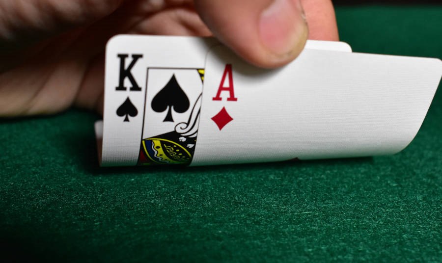 Male hand bending 2 cards on a Casino table