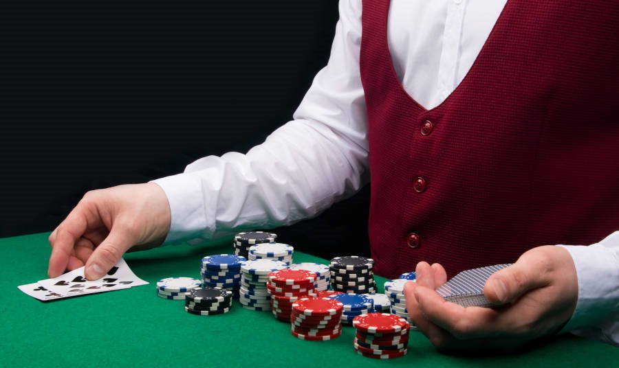Closeup of a casino dealer with cards and chips