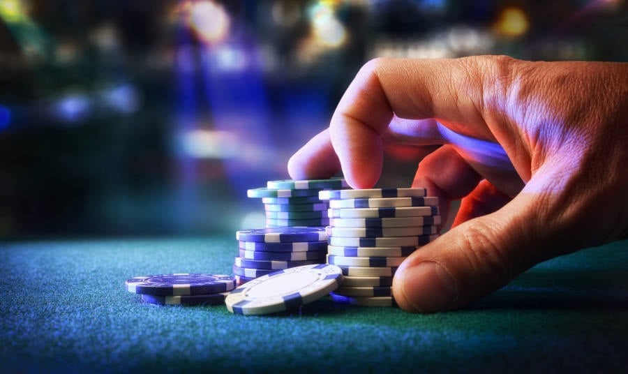 Hand placing chips on a casino gaming table