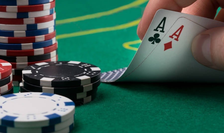 Hand raises for two winning cards on a green poker table