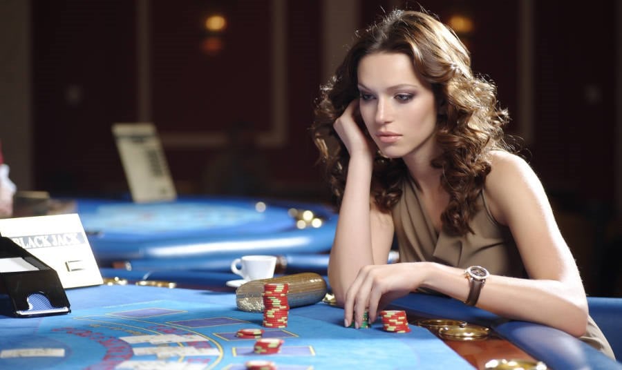 young beautiful woman playing blackjack in casino