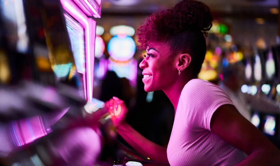 woman having fun playing slot machine at casino