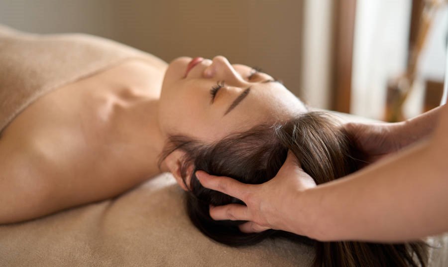 Woman receiving head massage at a spa