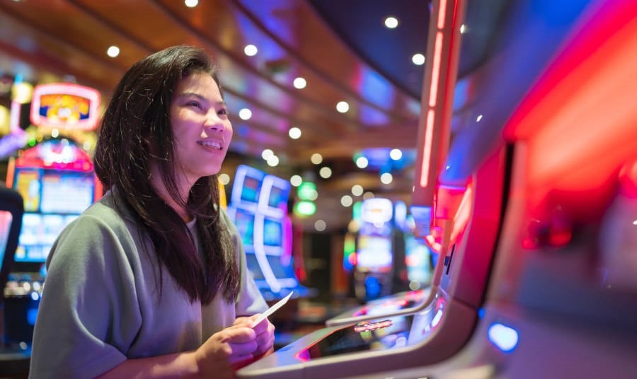 Lady at a slot machine with a ticket