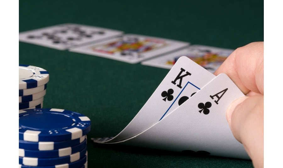 Man looking at cards at a poker table in a casino