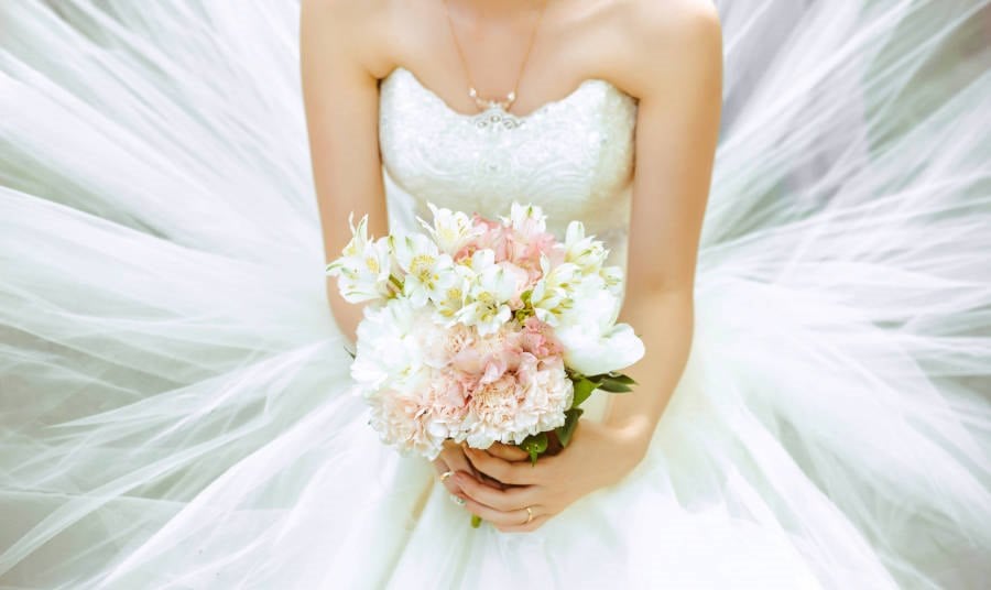 Bouquet of the bride in a magnificent white dress.