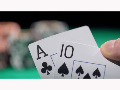 2 playing cards being held up at a Casino Table